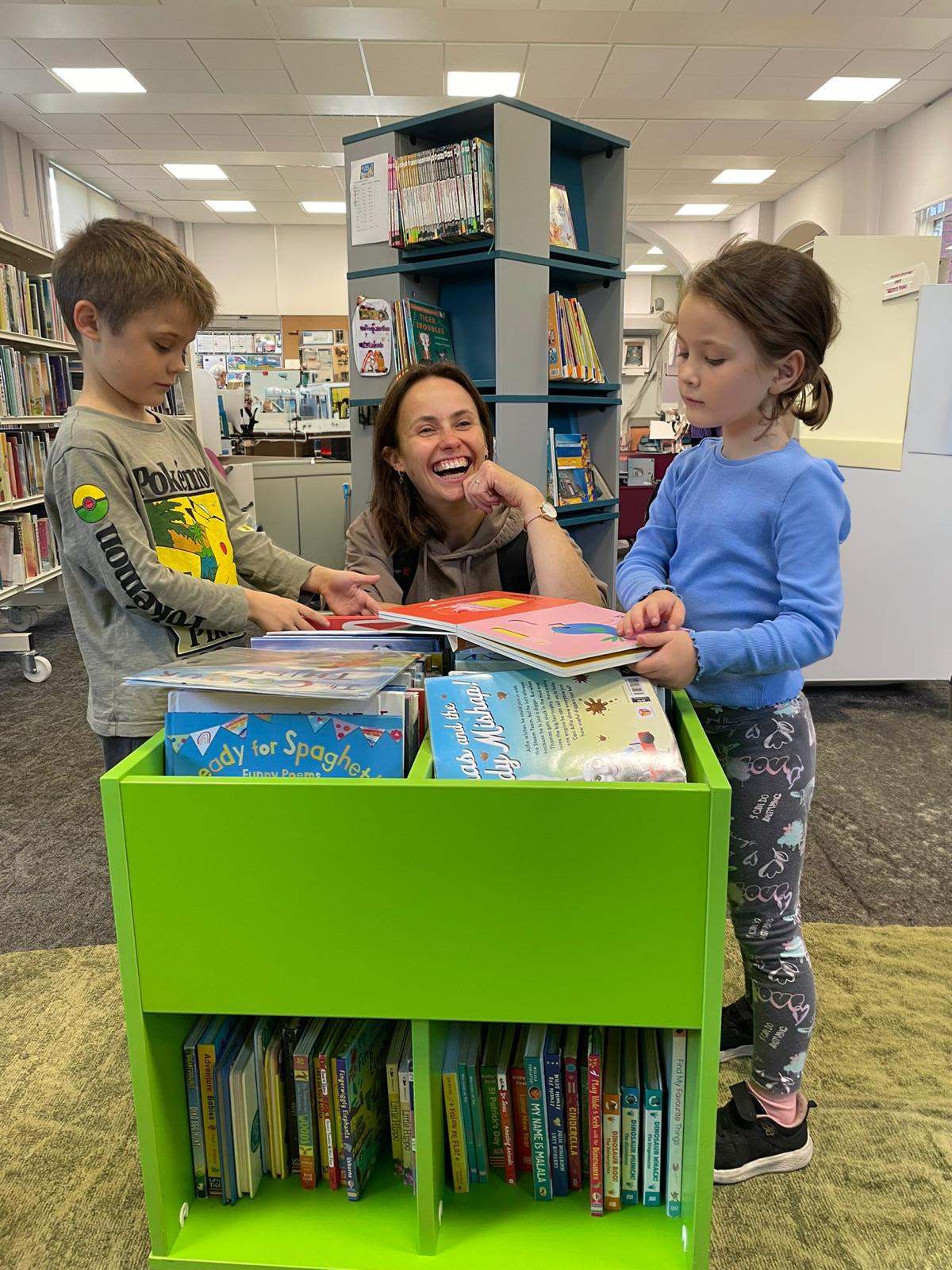 a mother with her children in a library having fun