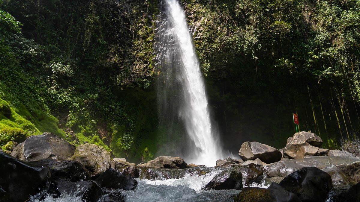 A waterfall crashes into a pool below. 
