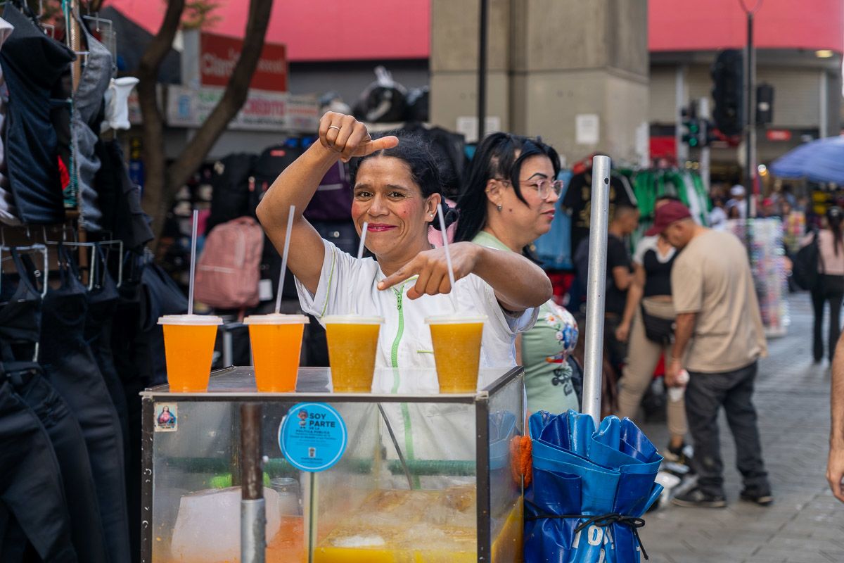 A woman sells homemade fresh juice drinks from her stand in Medellín city centre. 