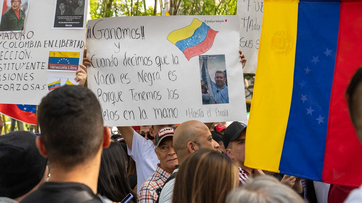 A man at a protest holds a sign with a message condemning a fraudulent election result. 