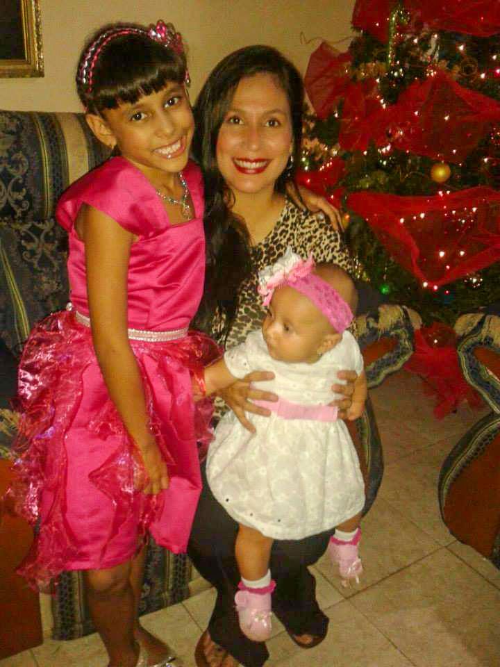 A mother and her two daughters: one is a child and the other a baby.