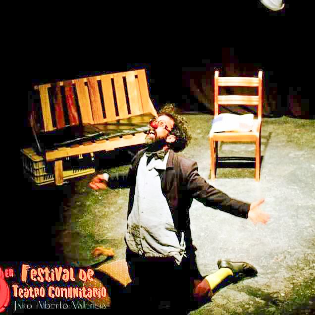 A man in costume performs a show. He is on his knees in a pleading gesture.